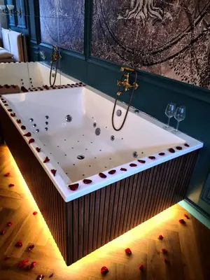 a jacuzzi tub in a room with wine glasses at Apartament z Jacuzzi Kraków ART Koletek in Kraków