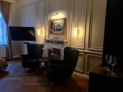 a living room with two chairs and a fireplace at Apartament z Jacuzzi Kraków ART Koletek in Kraków