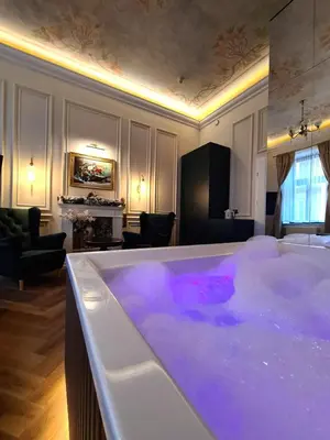 a large bath tub filled with purple water in a room at Apartament z Jacuzzi Kraków ART Koletek in Kraków