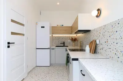 a kitchen with white cabinets and a white refrigerator at Premium City Center Apartment Ariańska in Kraków