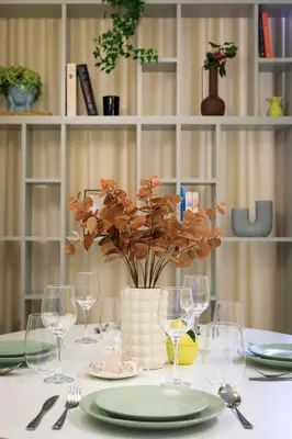 a table with plates and glasses and a vase with flowers at Premium City Center Apartment Ariańska in Kraków