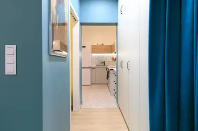 a hallway leading to a kitchen with a blue curtain at Premium City Center Apartment Ariańska in Kraków