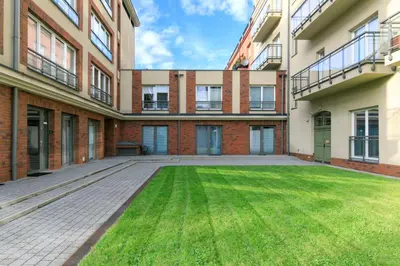 an empty courtyard of an apartment building with a lawn at Premium City Center Apartment Ariańska in Kraków