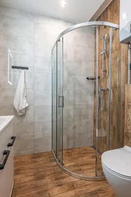 a shower with a glass door in a bathroom at Apartamenty Astra in Oświęcim