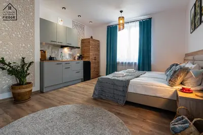 a bedroom with a large bed and a kitchen at Apartamenty Astra in Oświęcim