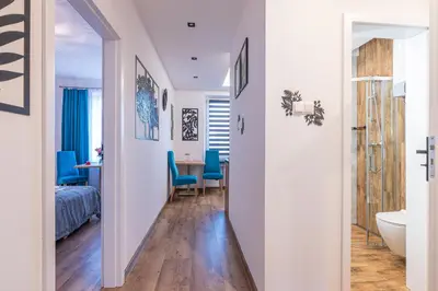a hallway leading to a bedroom with a bed and a bathroom at Apartamenty Astra in Oświęcim