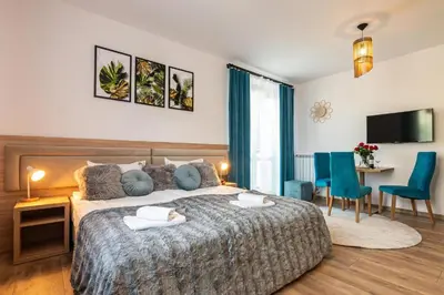 a bedroom with a bed and a table and chairs at Apartamenty Astra in Oświęcim
