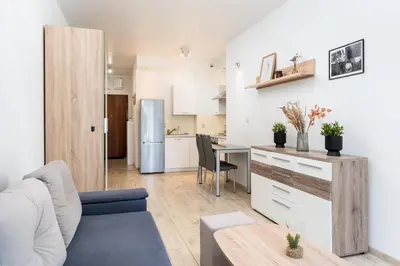 a white bedroom with a bed and a window at Dębniki Pleasant Studio by BookingHost in Kraków