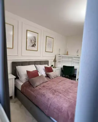 a bedroom with a large bed with two pillows at Apartament Lumière in Oświęcim
