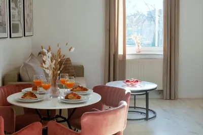 a dining room with two tables and chairs with food and drinks at Apartament Lumière in Oświęcim
