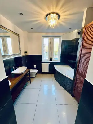 a large bathroom with two sinks and a tub and toilet at Apartament Lumière in Oświęcim