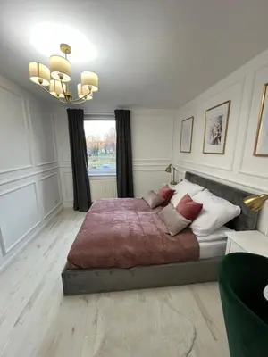 a bedroom with a large bed and a window at Apartament Lumière in Oświęcim