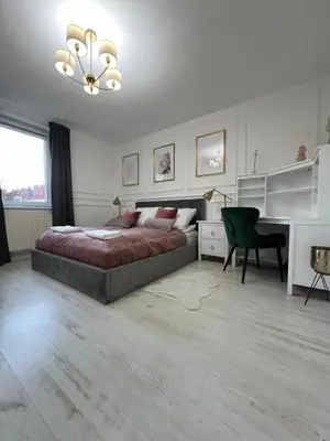 a bedroom with a bed and a desk and a chair at Apartament Lumière in Oświęcim