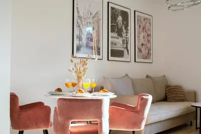 a living room with a table with chairs and a couch at Apartament Lumière in Oświęcim