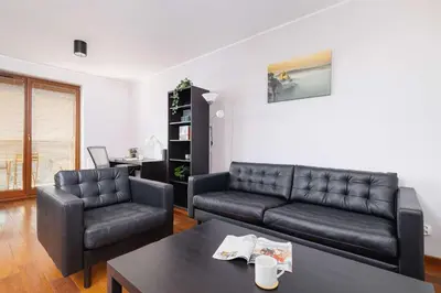 a living room with a couch and a table at Exceptional Apartment with Balcony by Noclegi Renters in Kraków