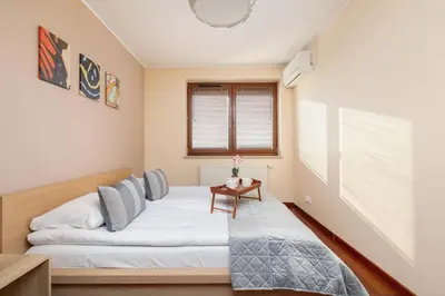 a bedroom with a bed and a table at Exceptional Apartment with Balcony by Noclegi Renters in Kraków