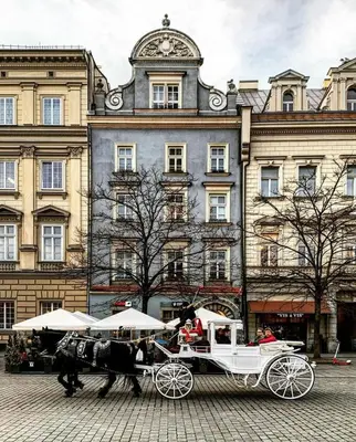 a horse drawn carriage in front of a building at Beautiful apartment in the city center, Angel City in Kraków
