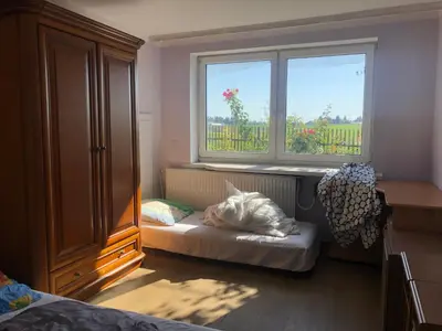 a bedroom with a bed and a large window at Hostel pracowniczy in Tropiszów
