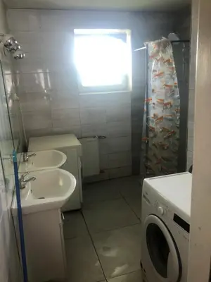 a bathroom with a washing machine and a sink at Hostel pracowniczy in Tropiszów