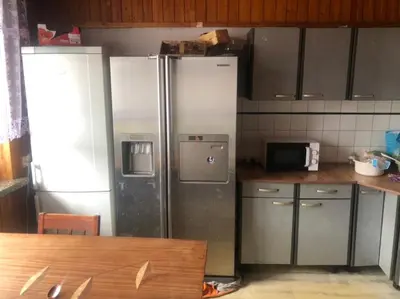 a kitchen with two stainless steel refrigerators in a kitchen at Hostel pracowniczy in Tropiszów