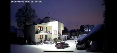 a car parked in front of a white house at Hostel pracowniczy in Tropiszów