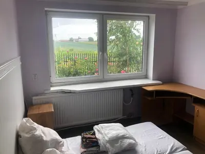 a bedroom with a bed and a window with a view at Hostel pracowniczy in Tropiszów
