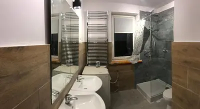 a bathroom with a sink and a toilet and a mirror at Hostel pracowniczy in Tropiszów