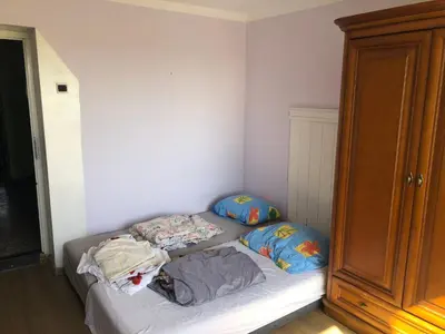 a bed with two pillows and a cat laying on it at Hostel pracowniczy in Tropiszów