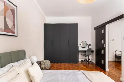 a bedroom with a bed and a desk with a chair at Słowackiego 43 Apartament in Kraków