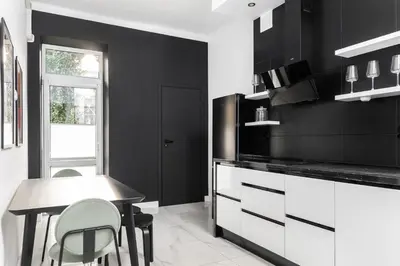 a black and white kitchen with a table and chairs at Słowackiego 43 Apartament in Kraków