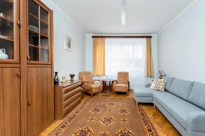 a bedroom with a bed with white sheets and a table at Mogilska Standard Apartment by BookingHost in Kraków
