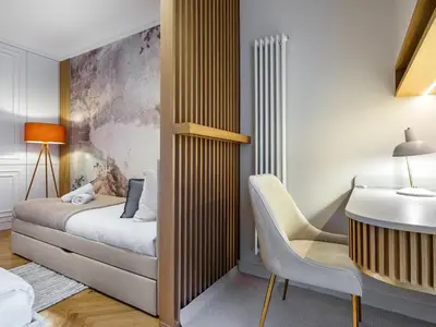 a bedroom with a bed and a desk and a chair at Wenecja by Tyzenhauz in Kraków