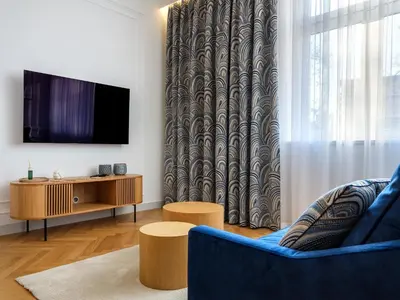 a living room with a tv and a blue couch at Wenecja by Tyzenhauz in Kraków