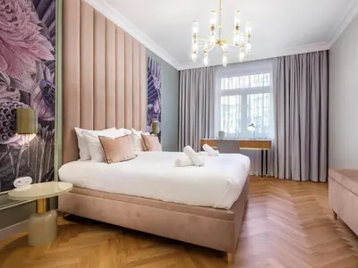 a bedroom with a large bed and a chandelier at Wenecja by Tyzenhauz in Kraków