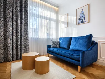 a living room with a blue couch and two tables at Wenecja by Tyzenhauz in Kraków