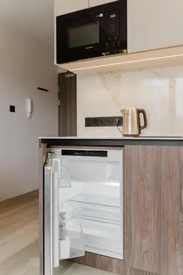 a kitchen with an open refrigerator with a microwave at Eleganckie Studio Royal w sercu Krakowa in Kraków