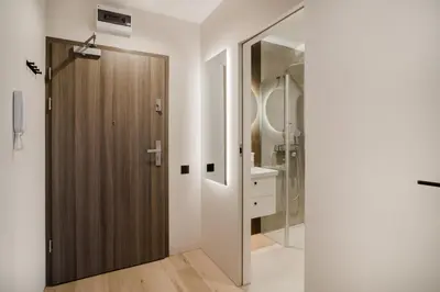 a bathroom with a shower and a wooden door at Eleganckie Studio Royal w sercu Krakowa in Kraków