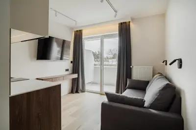 a living room with a couch and a television at Eleganckie Studio Royal w sercu Krakowa in Kraków