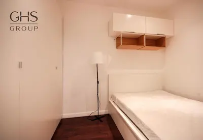 a small bedroom with a bed and a lamp at Przytulny apartament w sercu Krakowa Old Town in Kraków