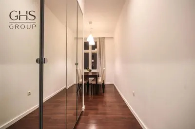 a hallway with a table and a glass door at Przytulny apartament w sercu Krakowa Old Town in Kraków