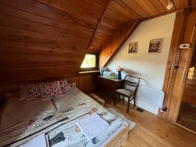 a bedroom with a bed and a desk in a room at Chata pod lasem z balią i sauną in Myślenice