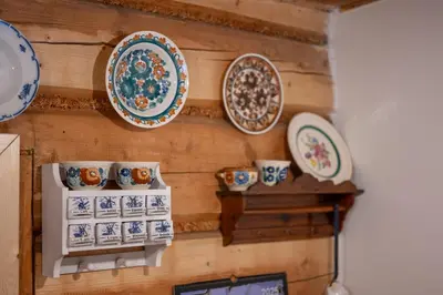 a wall with plates and cups on a wall at Chata pod lasem z balią i sauną in Myślenice