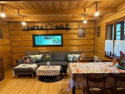 a living room with a couch and a table at Chata pod lasem z balią i sauną in Myślenice