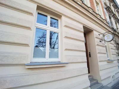 a window on the side of a building with a clock at Apartamenty Czapskich in Kraków