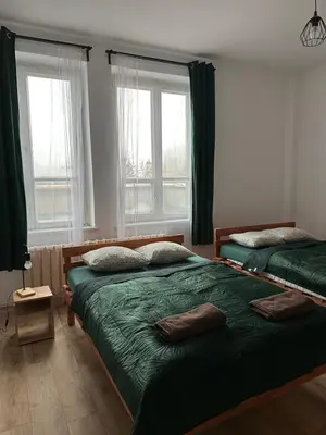 a bedroom with two beds and two windows at New KiKo in Kraków