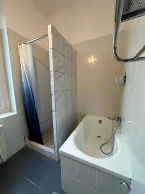 a bathroom with a tub with a shower and a sink at New KiKo in Kraków