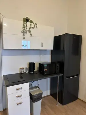 a kitchen with a counter and a black refrigerator at New KiKo in Kraków