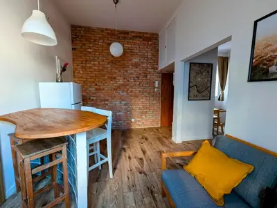 a living room with a blue couch and a brick wall at Dąbrowskiego 15 by Homeprime in Kraków