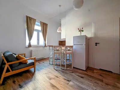 a kitchen with a refrigerator and a table in a room at Dąbrowskiego 15 by Homeprime in Kraków