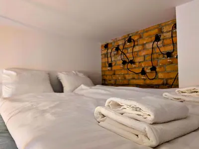 a bed with white sheets and towels on it at Dąbrowskiego 15 by Homeprime in Kraków